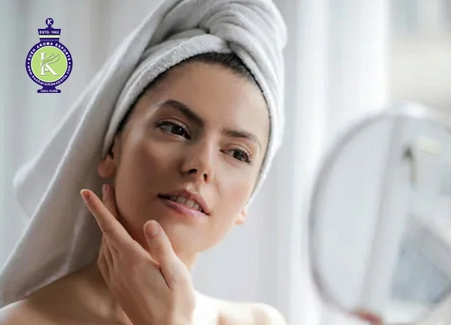 Woman applying skincare after a shower using essential oils for dehydrated skin to nourish and restore natural moisture.
