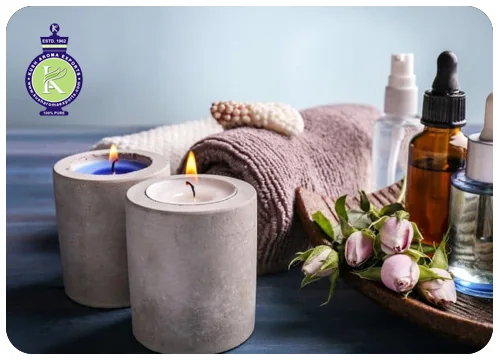 Essential oils for candle making: lit scented candles with essential oil bottles and roses